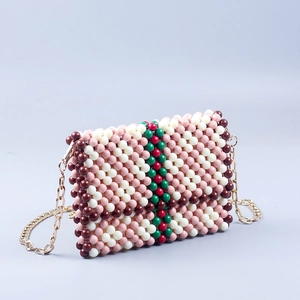 Detail of handmade beaded bag with green-red stripes and gold chain strap