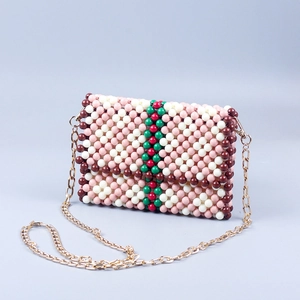 Detail of handmade beaded flap bag with green and red stripes and gold chain strap