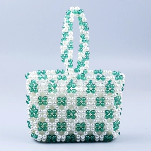 Detailed close-up of handmade green and white acrylic beaded handbag with floral pattern
