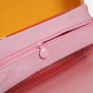 Detail of pink fabric zipper and red glitter translucent material on a pencil pouch