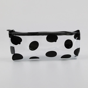Detail showing transparent PVC pencil case with black polka dots and zip closure