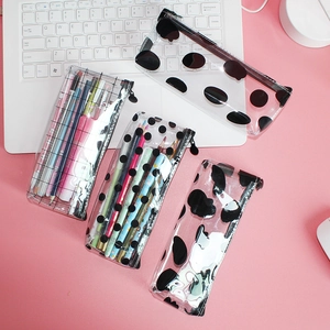 Macro detail of transparent PVC pencil cases with four geometric patterns on a pink desk
