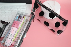 Transparent PVC pencil cases with mesh and polka dots featuring black zippers and stationery
