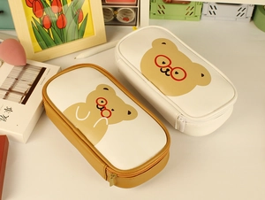 Top-down view of cute Japanese-style bear pencil cases in cream and brown PU leather
