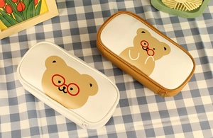 Detail of cream and brown PU leather pencil cases featuring cute bear print and zipper