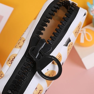Close-up of cute cartoon pencil case with oversized chunky zipper and circular ring puller