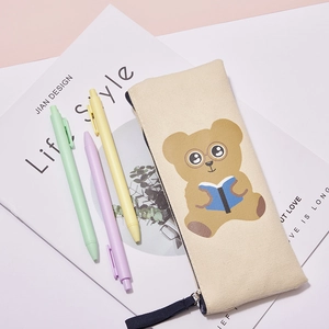 Detailed view of beige canvas pencil case with cute cartoon bear and macaron pens