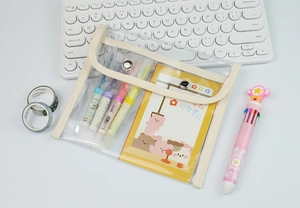 Detailed view of clear PVC stationery pouch with canvas trim and metal snap closure