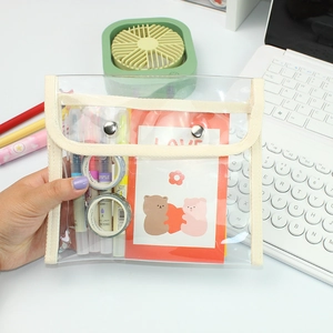 Macro shot of large capacity transparent PVC pencil case with cream webbing and metal snaps