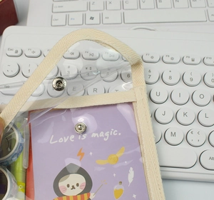 Detail showing transparent PVC pencil case with snap button and wizard cat card