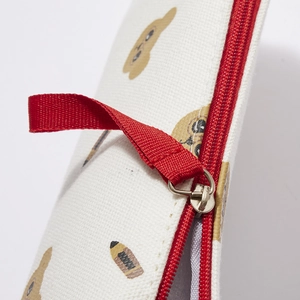Detail of red zipper closure and canvas texture with cute bear print on stationary bag