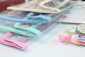 Detail of large transparent waterproof pencil cases with side handles and color zippers