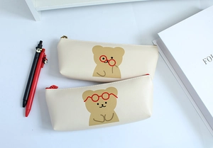 Close-up of creamy white PU pencil case featuring cute brown cartoon bear illustrations