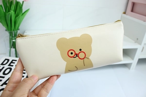 Close-up of cream PU pencil case featuring minimalist bear design and sturdy zipper