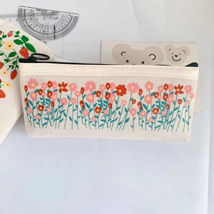 Close-up of beige canvas pencil case with pink floral patterns and a black zipper closure