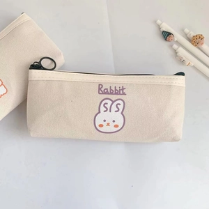 Close-up of off-white canvas pencil case with purple cartoon rabbit and zipper detail
