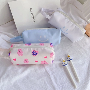 Three aesthetic canvas pencil cases with smiling faces and cute bears in pastel colors