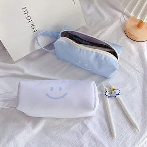 Detail of minimalist canvas pencil case with blue smile pattern and cloud decorative pens