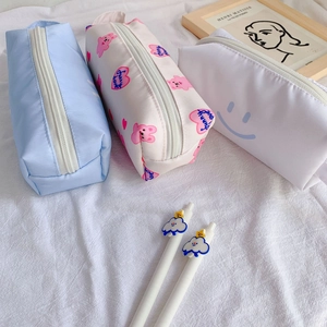 Detailed view of three pastel canvas pencil cases with rabbit and smiley face patterns