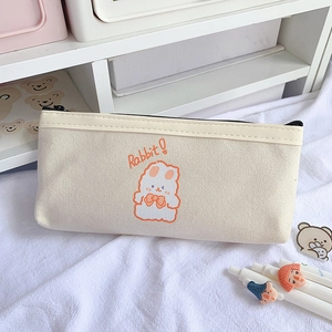 Détail d'une trousse en toile beige avec un lapin orange et une fermeture éclair robuste