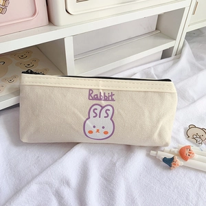 Détail du plumier en toile avec illustration de lapin violet et fermeture éclair noire