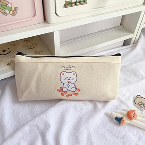 Détail de la trousse en toile avec imprimé fraise et ours sur tissu blanc plissé