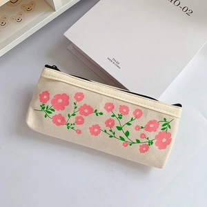 Detailed view of the canvas pencil case featuring fresh pink floral patterns on a desk