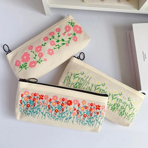 Flat canvas pencil bags with floral embroidery, zip closure, and sturdy texture