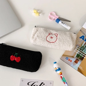 Macro detail of soft fleece stationery pouches with cherry and bear embroidery