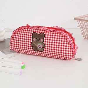 Cute red plaid pencil case with brown bear embroidery and lace detail on white desk
