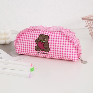 Close-up of pink plaid stationery bag with peach bear embroidery and ruffle trim detail