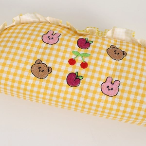Close-up of yellow checkered stationery bag with cute rabbit and bear embroidery
