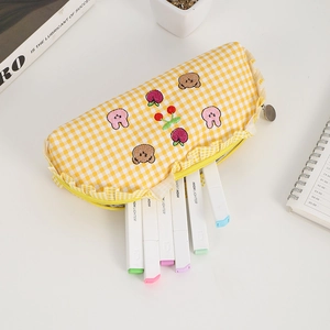 Detail of yellow checkered pencil case with cute bear embroidery and ruffle edges