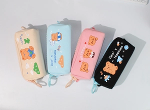 Détail de trousses en toile avec grandes fermetures éclair et motifs d'ours mignons