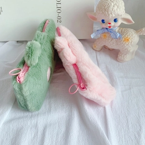 Close-up of pink and mint green plush pencil cases with zippers and circular pullers