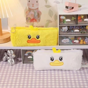 Cute plush duck pencil case with soft faux fur and zipper on a cozy student desk