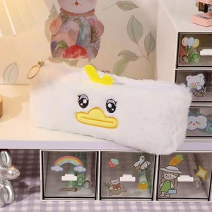 Close-up of cute plush duck pencil case featuring a gold zipper ring and soft white fur