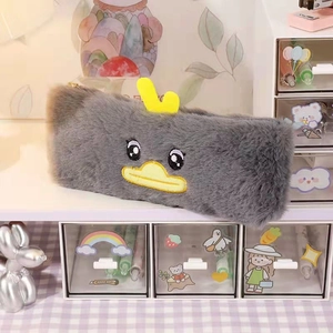 Close-up of grey plush duck pencil case with embroidered eyes and yellow felt beak detail