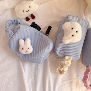 Detailansicht der hellblauen Cord-Kosmetiktasche mit Plüschhase und Make-up-Artikeln