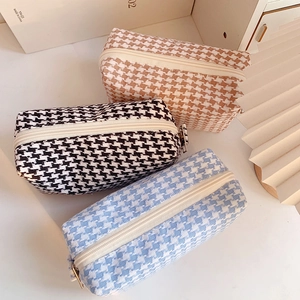 Three houndstooth zipper pouches in black, brown, and blue colors for makeup or stationery