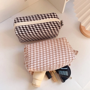 Top view of houndstooth makeup bags showing storage capacity with cosmetics