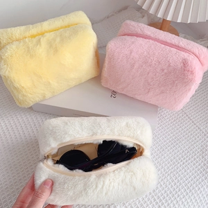 Astuccio in peluche macaron che mostra l'interno con occhiali da sole nella borsa bianca