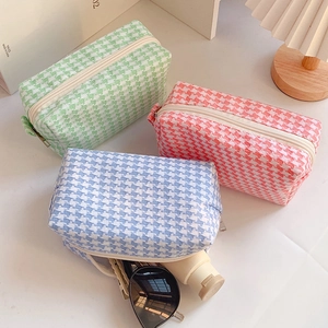 Candy colored houndstooth makeup bags in green, pink, and blue with zipper closure