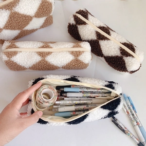 Macro view of checkered plush pencil cases in black, coffee, and beige colors
