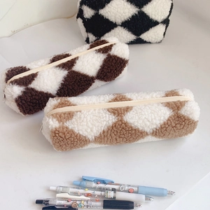 Macro shot of fluffy plaid pencil cases in black, dark coffee and light tan colors