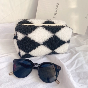 Close-up of black and white checkered plush pencil case with soft faux fur texture