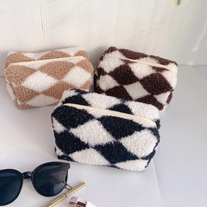Detailed view of checkered plush pencil cases in black, brown, and beige with zippers