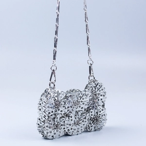Silver metallic chain bag with handcrafted hollow metal leaf pattern and long shoulder strap