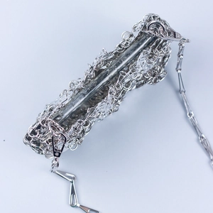 Silver metallic woven crossbody bag with intricate floral metal petals and chain strap