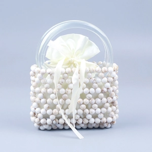 Macro view of beaded handbag with marble texture beads and transparent acrylic handle